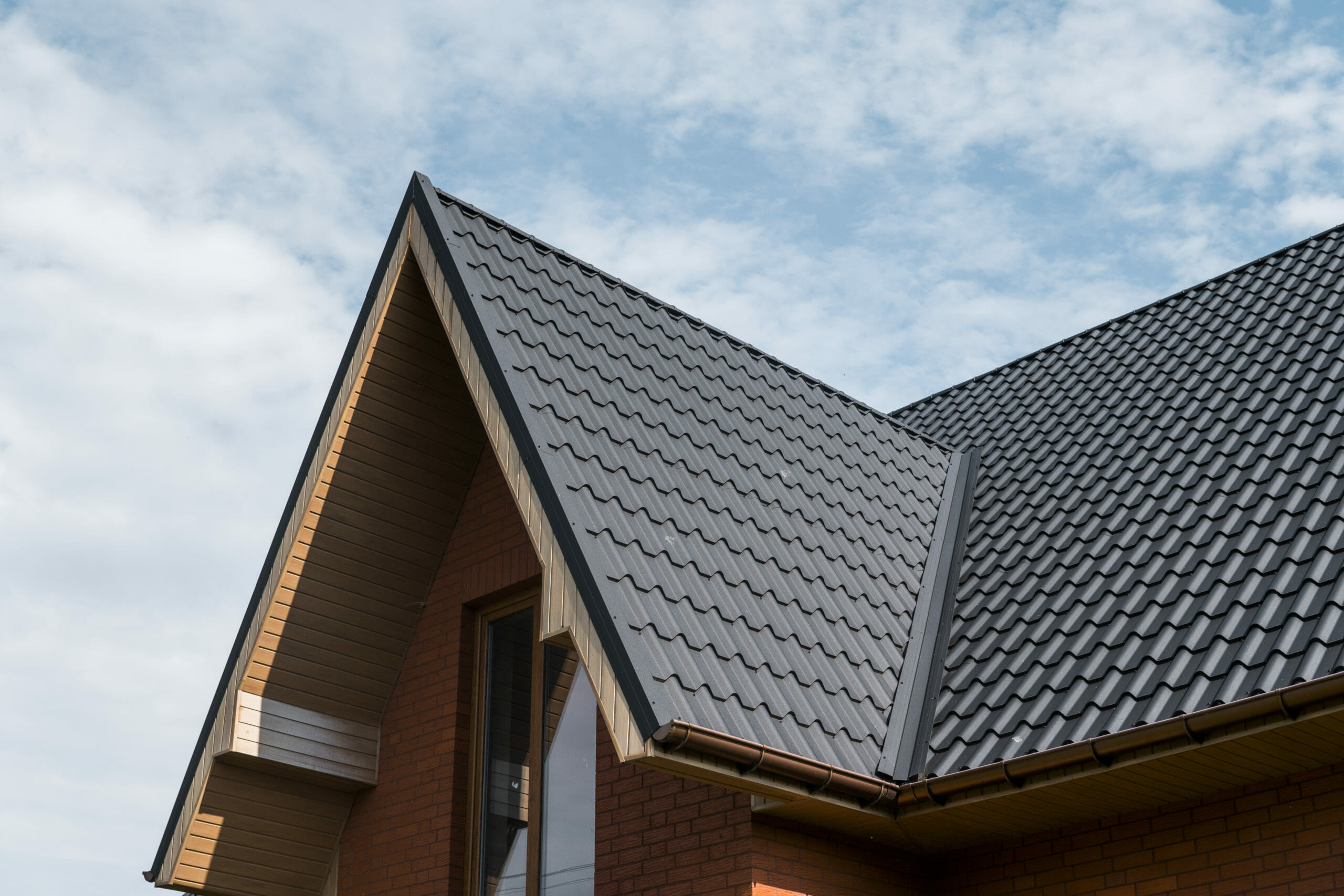 Modern roof covered with tile effect PVC coated brown metal roof sheets. Roofing and Storm Damage Restoration in Rockville, VA